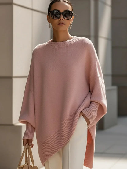Model wearing the dusty pink version of the jumper with sunglasses, white trousers and a beige handbag. 11