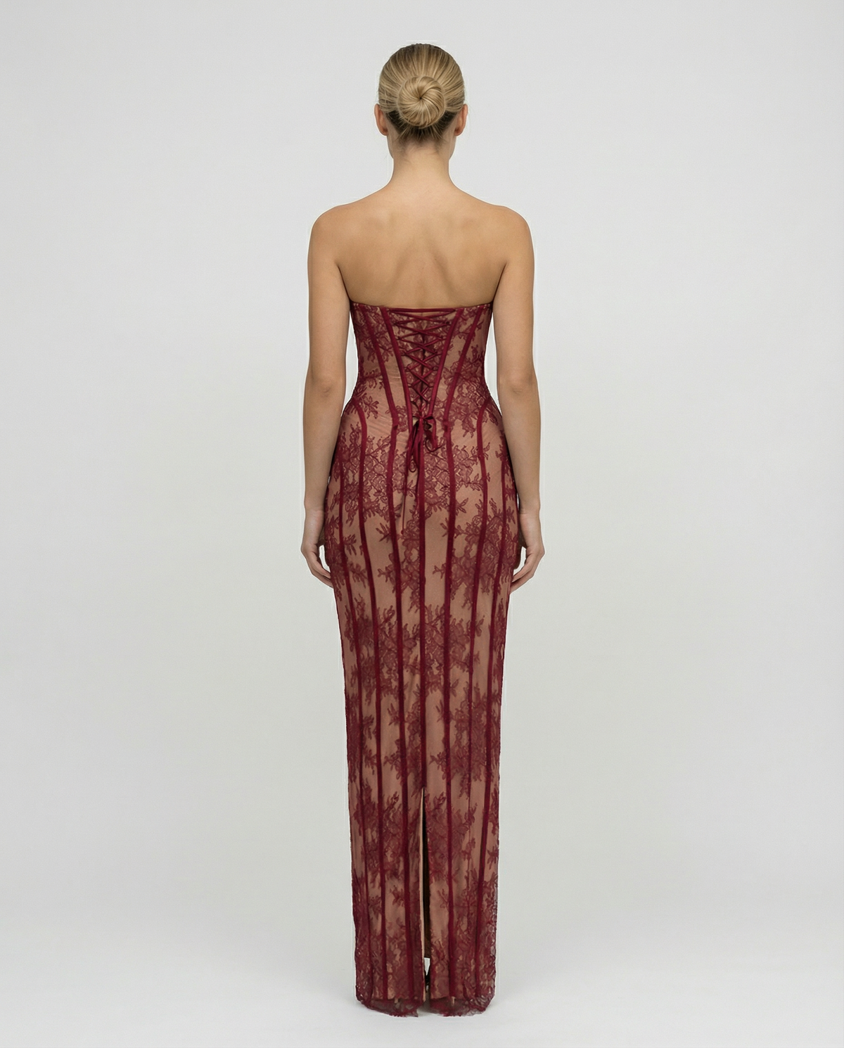 Back view of the burgundy dress showing the lace-up corset back, ribbon ties and a slit at the hem. 2