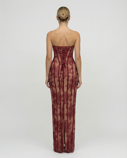 Back view of the burgundy dress showing the lace-up corset back, ribbon ties and a slit at the hem. 2
