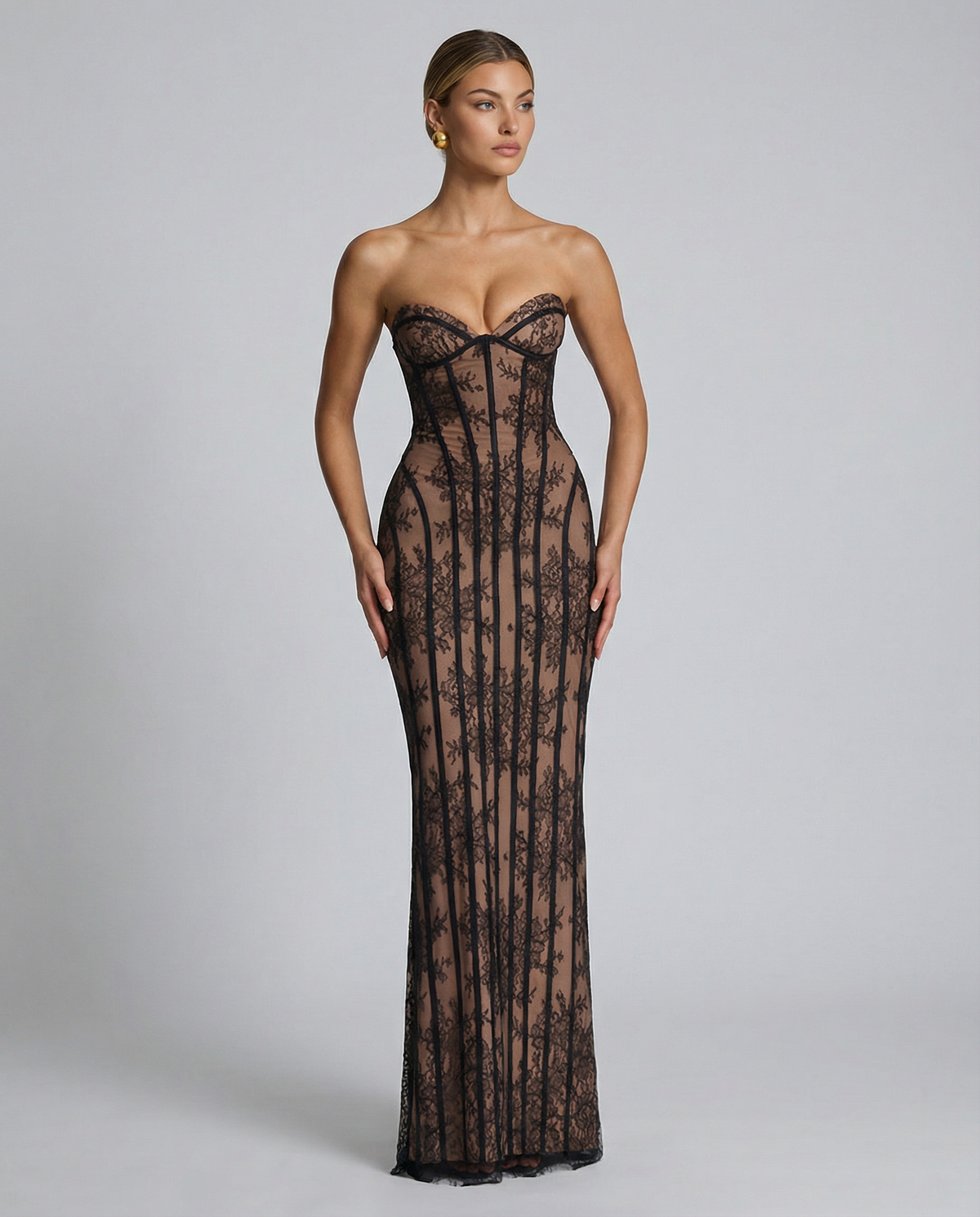 Model in the black lace maxi dress with sleek hair, standing with arms by her sides to show the full-length fitted shape. 8