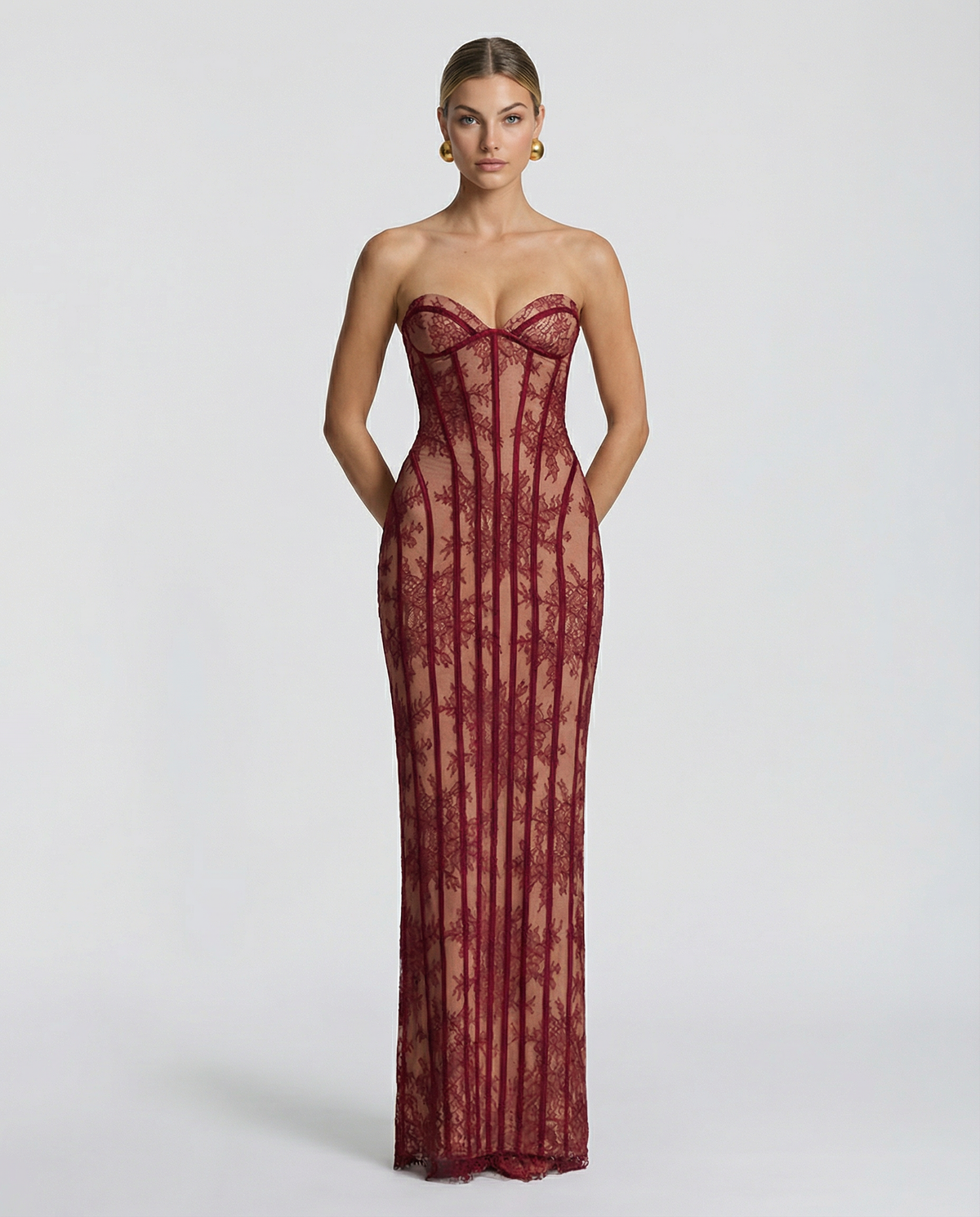 Model facing forward in the burgundy lace maxi dress, showing the sweetheart bustier neckline and vertical corset boning over a nude lining. 1