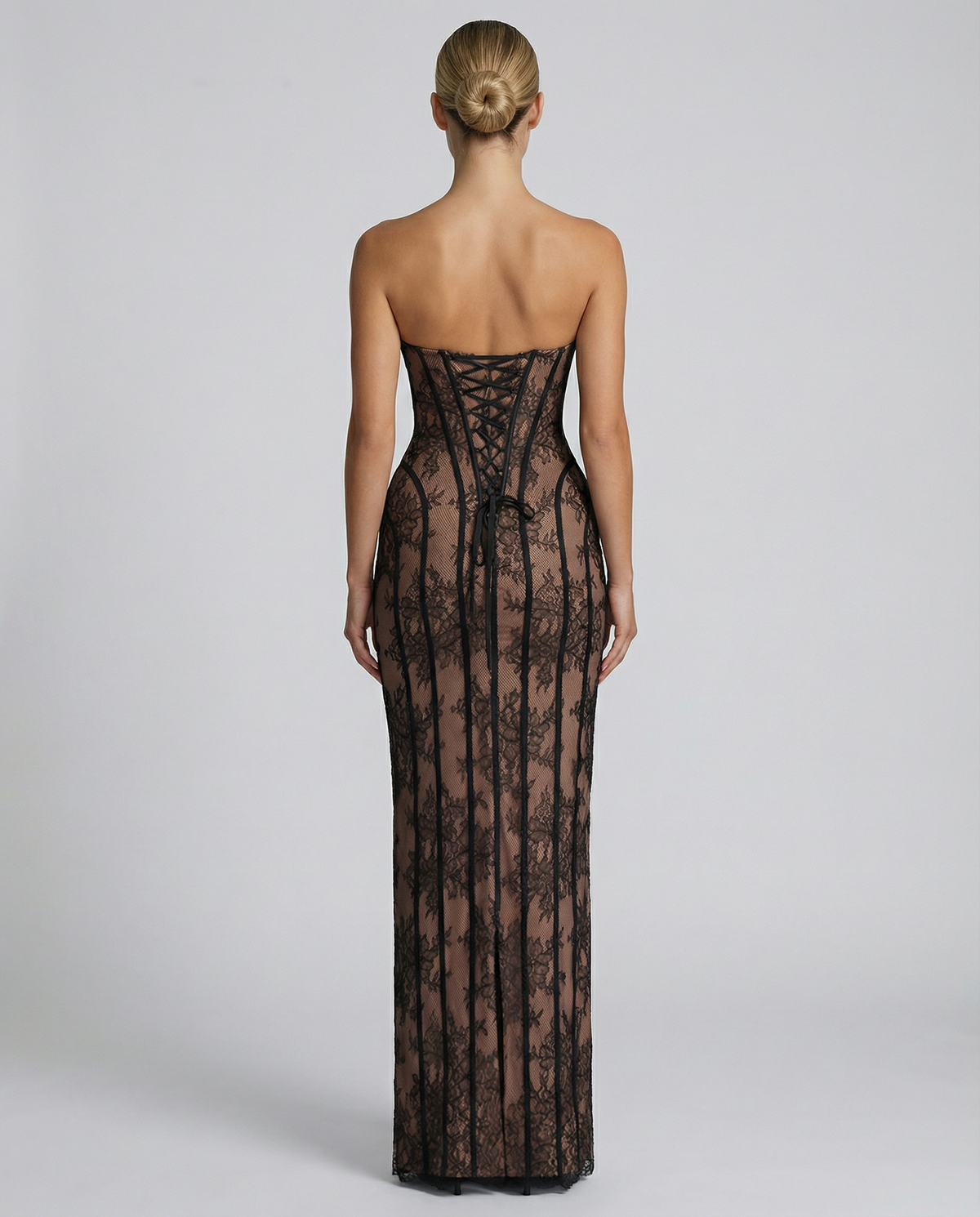 Back view of the black lace dress, showing the corset lacing, bow ties and central hem slit. 6