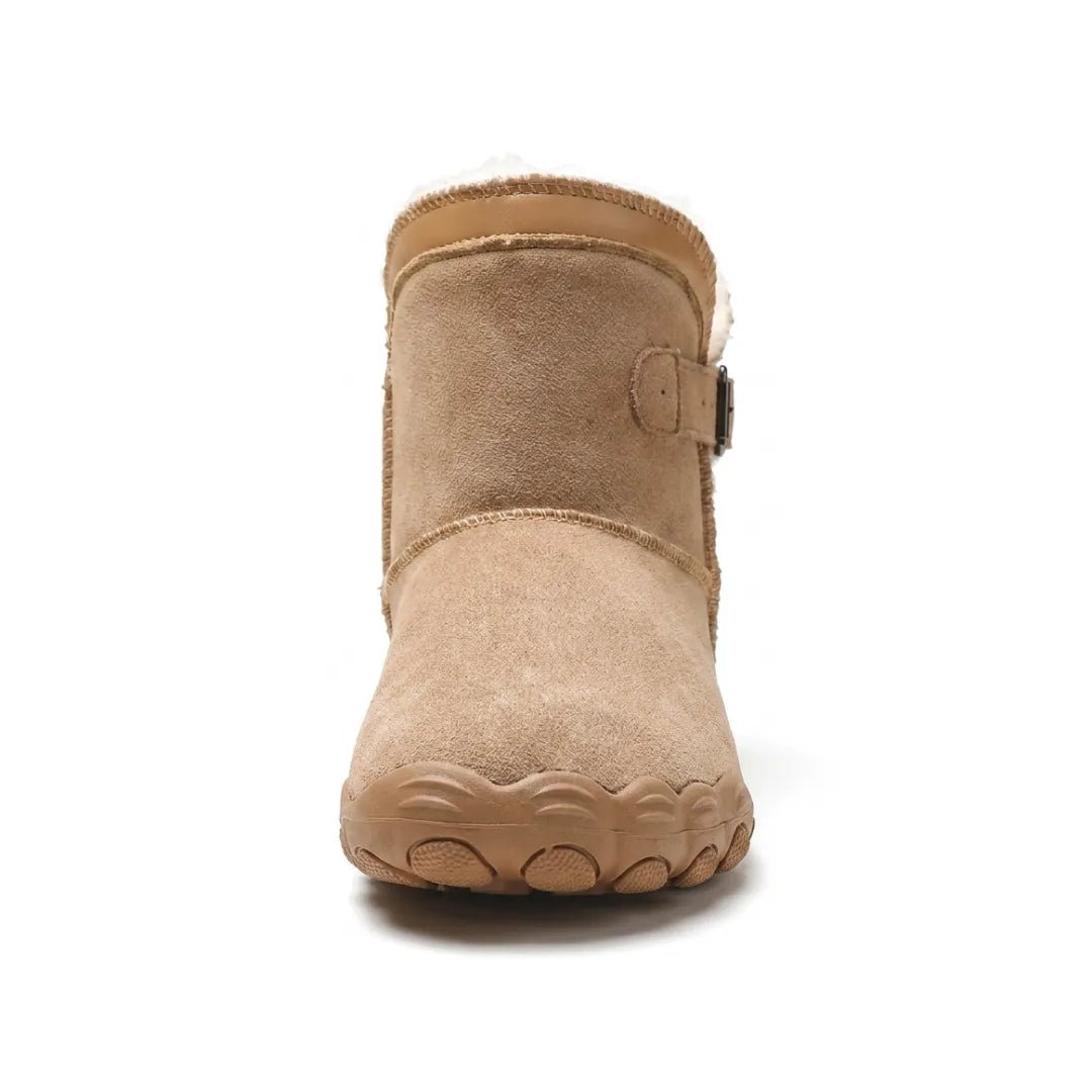 Front view of a tan suede boot showing the broad rounded toe, fleece collar and side buckle 26