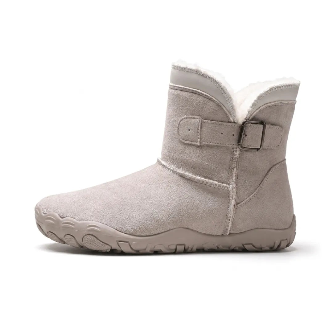Side view of a light grey suede ankle boot with buckle strap, fleece lining and thick treaded sole 28