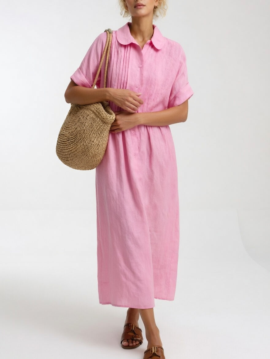 Model in the pink dress with a straw bag over her shoulder, hands clasped at the waist, showing the pleated front. 4
