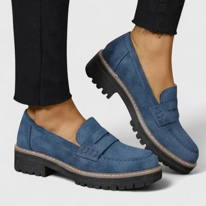 Blue suede-look loafers worn with black cropped trousers, showing the side profile and chunky tread 4