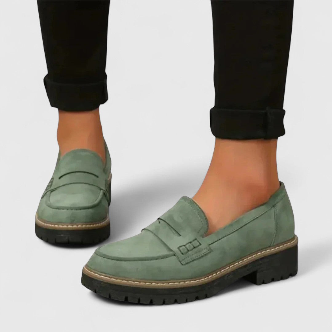 Sage green suede-look loafers worn with rolled black trousers, showing the front and side 6