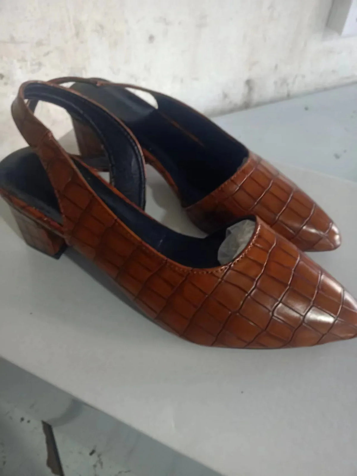 Brown croc-effect slingbacks from the side on a white surface, showing the block heel and strap 8