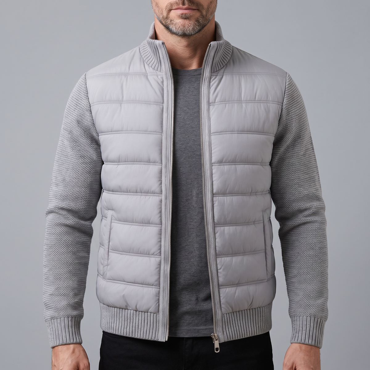 Bearded man wearing the light grey quilted jacket unzipped over a dark grey t-shirt, front view 1