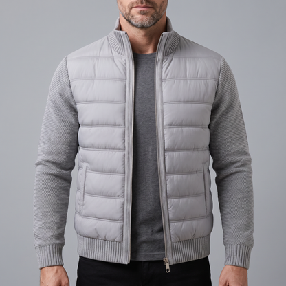 Bearded man wearing the light grey quilted jacket unzipped over a dark grey t-shirt, front view 1