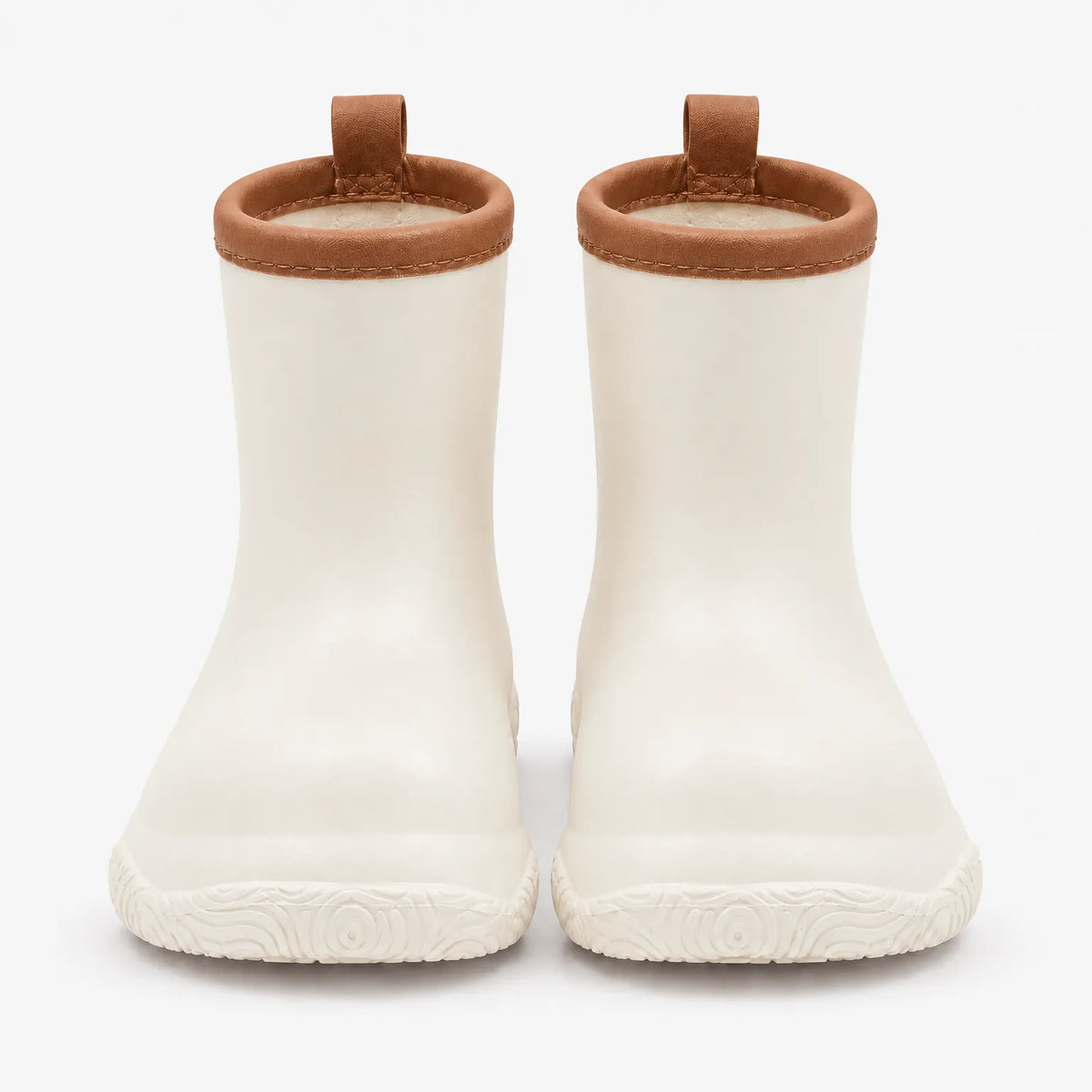 Front view of cream wellies with tan brown collars, stitched trim and pull loops, above a patterned sole. 10