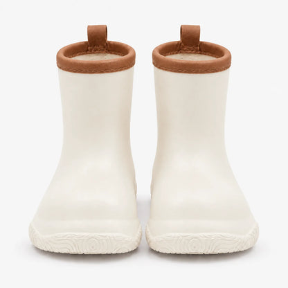 Front view of cream wellies with tan brown collars, stitched trim and pull loops, above a patterned sole. 10