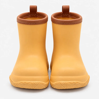 Front view of mustard yellow wellies with brown stitched collars and pull loops above a swirl-patterned sole. 11