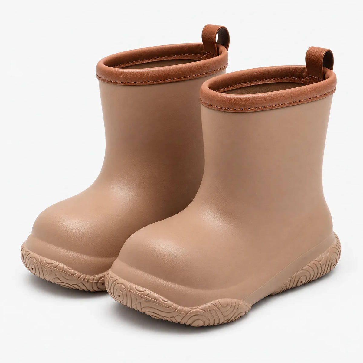 Pair of tan pull-on wellies seen from the front at an angle, with brown stitched collar, back pull loops and patterned soles. 2