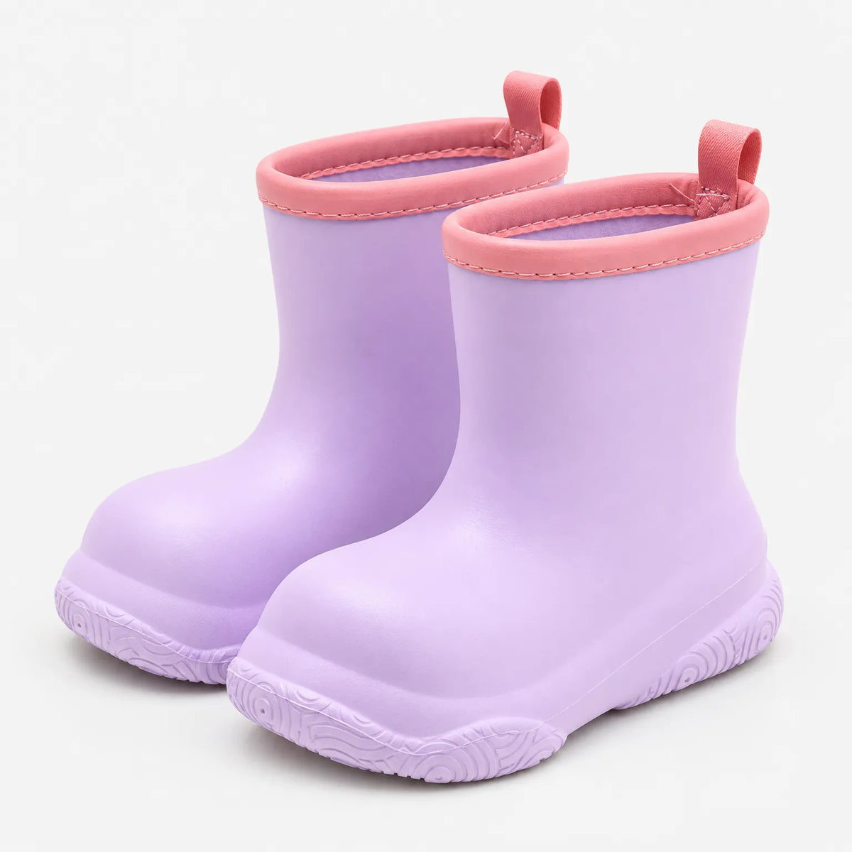 Pair of lilac pull-on wellies angled front view, with pink stitched collars, pink pull loops and a patterned sole. 4