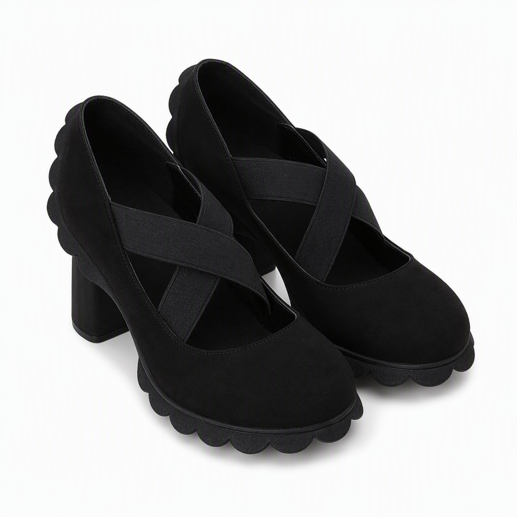 Pair of black suede-look block heel Mary Janes with crossed elastic straps and scalloped sole edges, shown from the front on white. 8