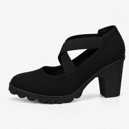 Single black suede-look block heel with crossed elastic straps and scalloped black sole, shown in side profile on white. 13