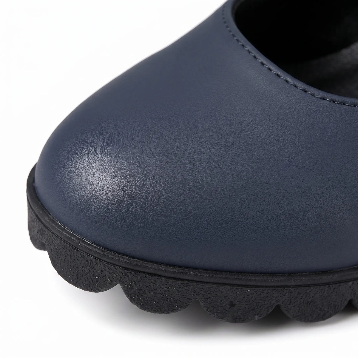 Extreme close-up of a navy shoe toe showing smooth leather-look texture, stitching and the scalloped black sole edge. 7