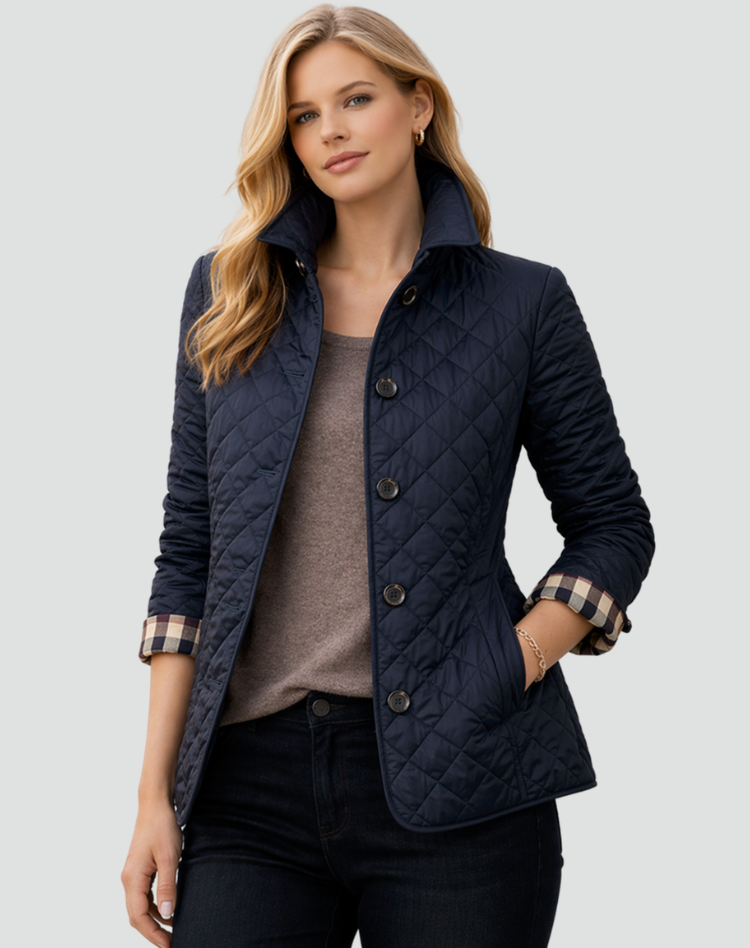 Model wearing the navy quilted jacket with a raised collar and checked cuffs, over a taupe top and dark jeans. 5