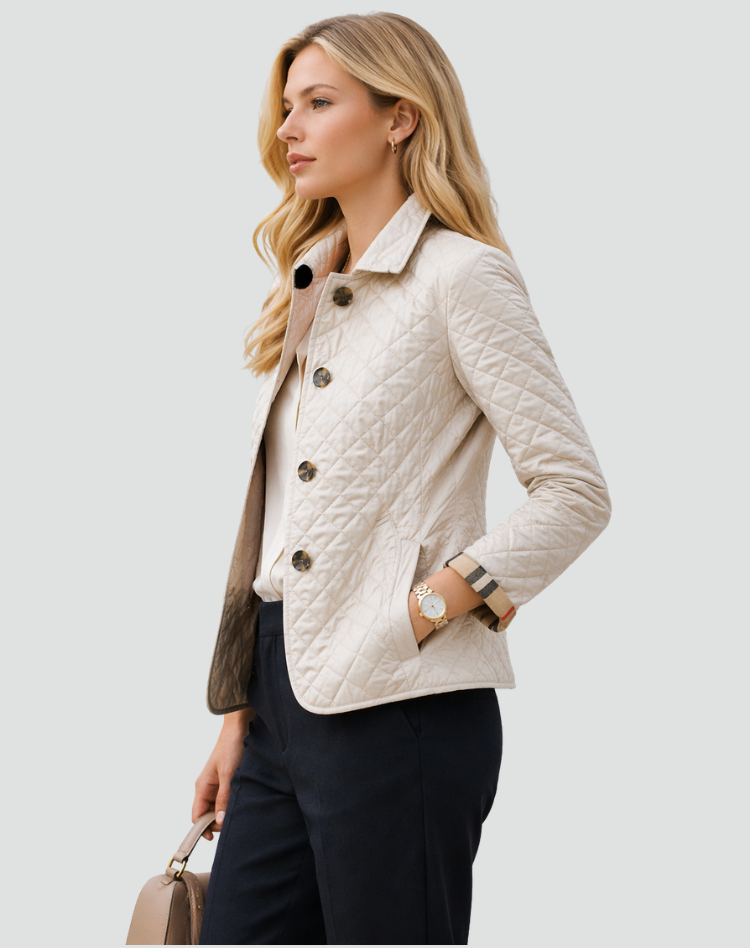 Side view of the cream quilted jacket on a model, showing the diamond stitching, front pocket and buttons, with a checked cuff. 7