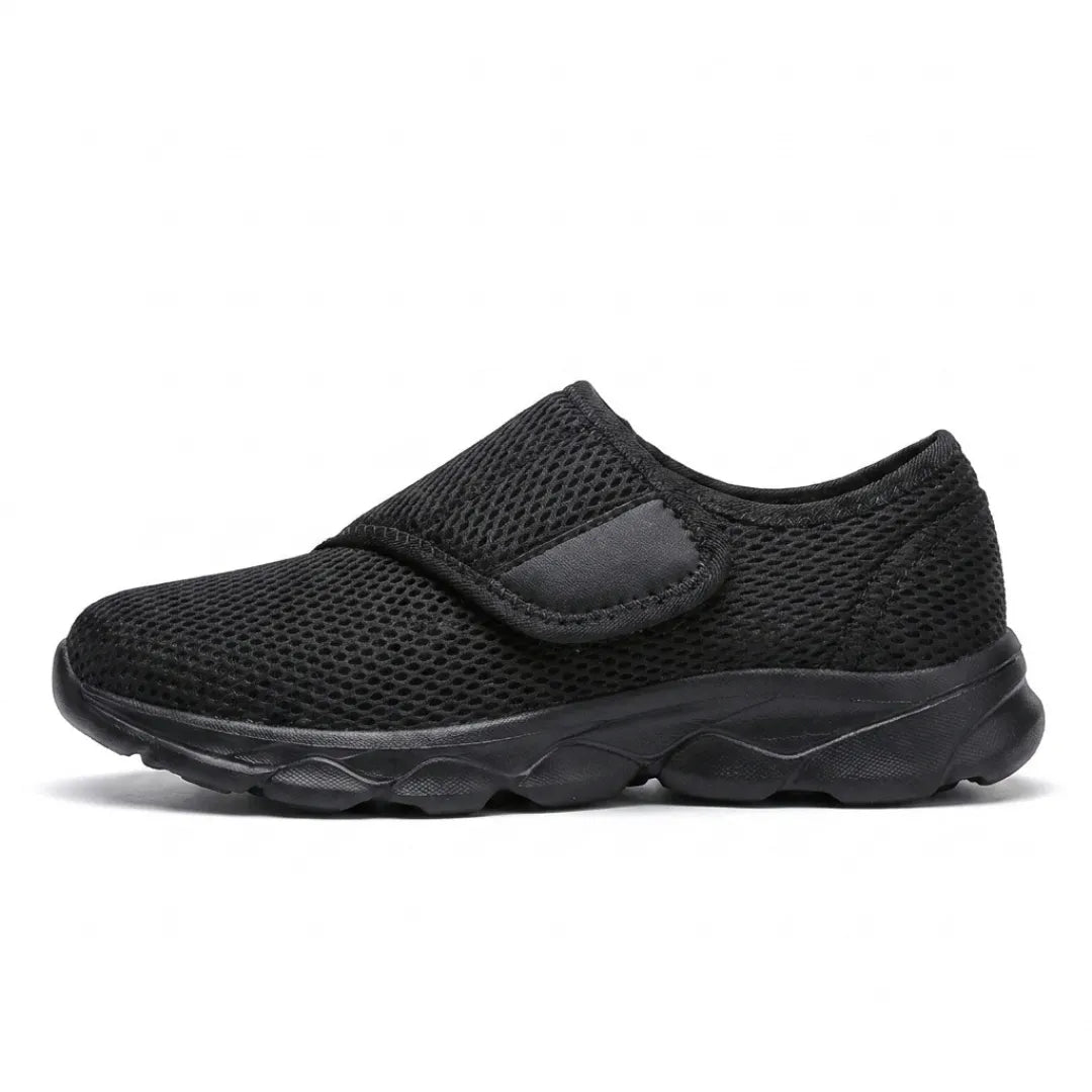 Side view of an all-black version with black mesh upper, wide strap and black sole. 10