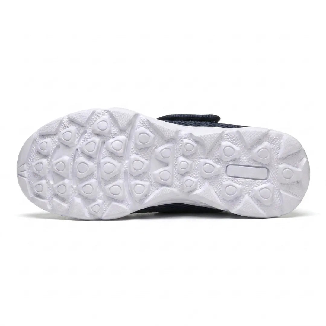 Underside of the white sole showing the raised rounded-triangle grip pattern, with the navy upper and strap just visible above. 9