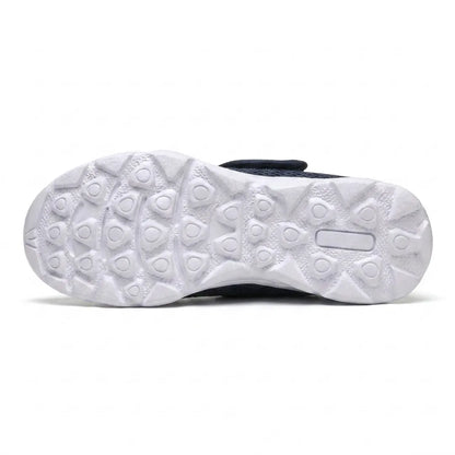 Underside of the white sole showing the raised rounded-triangle grip pattern, with the navy upper and strap just visible above. 9