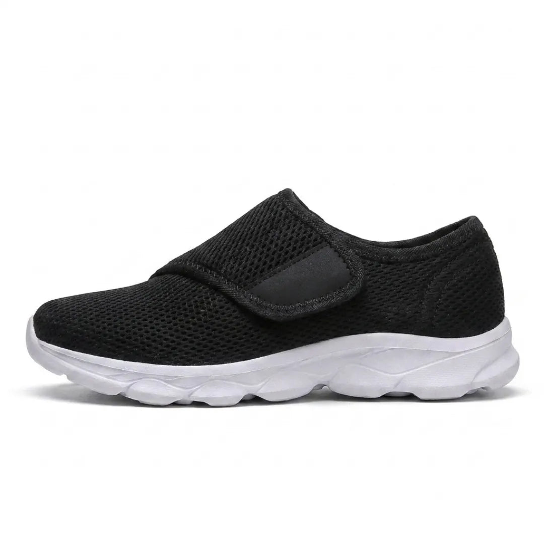 Side view of a black mesh shoe with a wide strap and contrasting white sole. 19