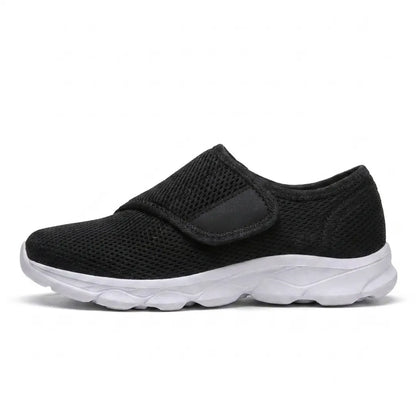 Side view of a black mesh shoe with a wide strap and contrasting white sole. 19