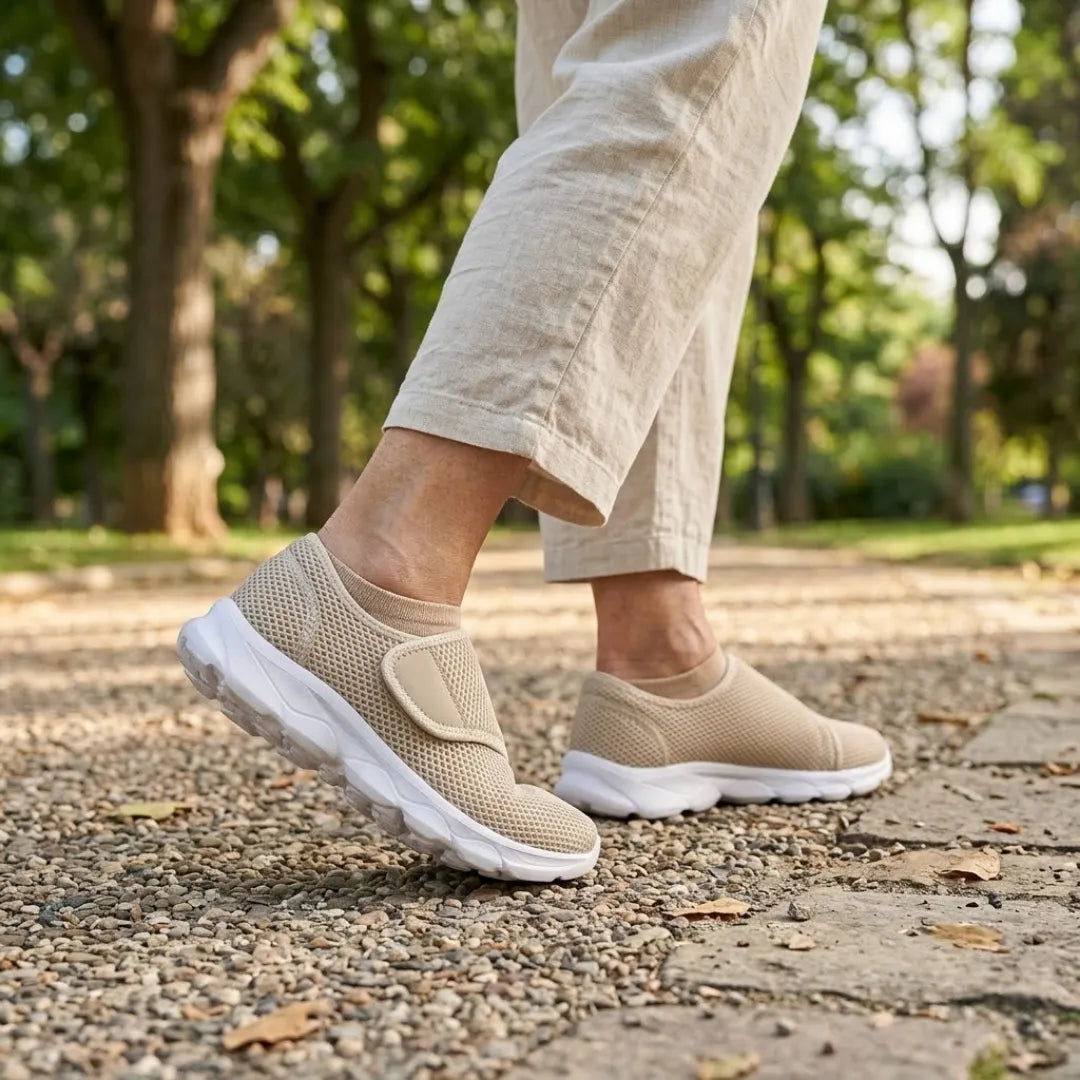 Person walking on a gravel park path wearing beige mesh shoes with white soles, beige socks and linen trousers. 29