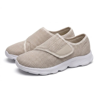Pair of beige mesh shoes with white soles and hook-and-loop straps, seen from the front three-quarter angle. 34
