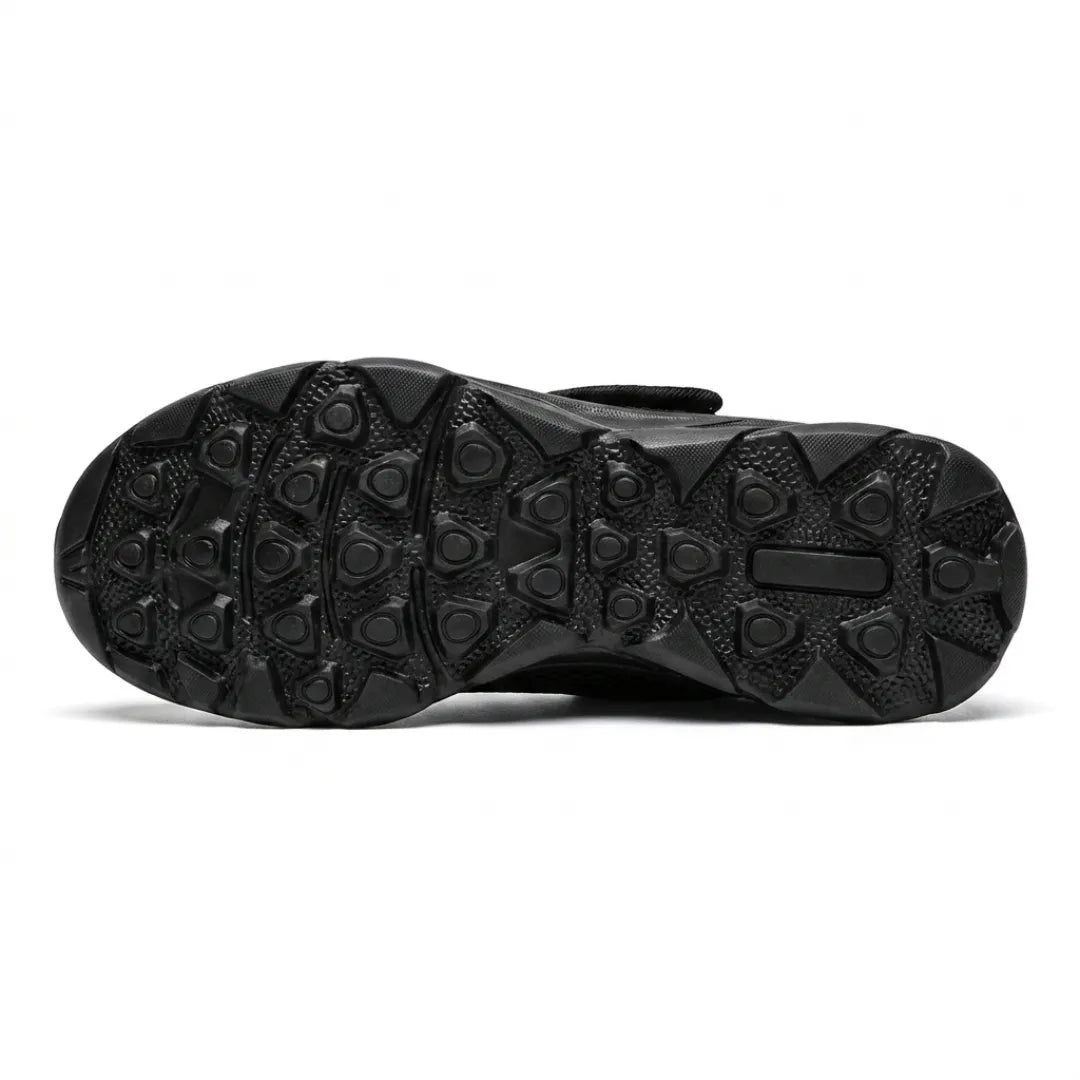 Underside of the black sole showing the raised rounded-triangle grip pattern, with the strap just visible above. 18