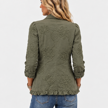 Back view of the olive green jacket with large embroidered flowers and trailing vines, finished with a ruffled hem. 5