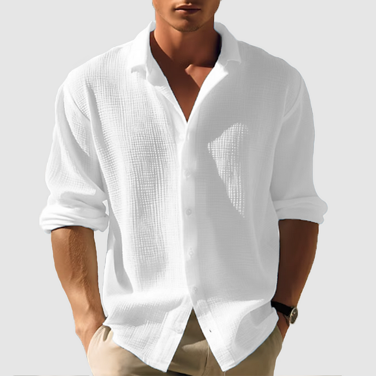Model wearing the textured shirt in white, sleeves rolled to the forearm, open collar, shown front on with hands in pockets. 2