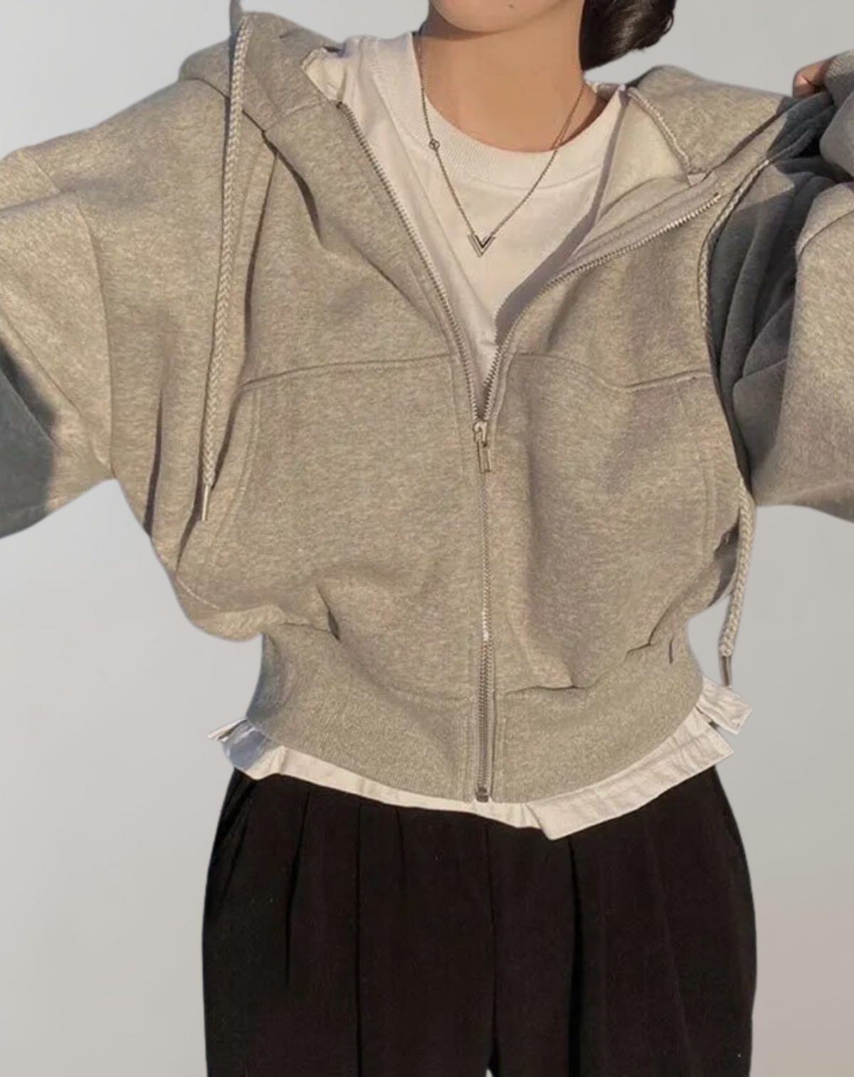 Marl grey hoodie worn open over a white tee and black trousers, showing the zip, drawstrings and ribbed waistband. 5