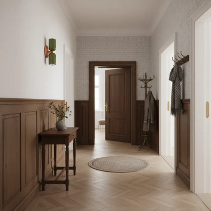 Green double-shade wall lamp with a coral bracket in a traditional hallway with wood panelling, herringbone flooring and a console table. 7