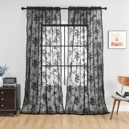 Pair of black rose lace curtain panels hung on a dark rod at a window, with scalloped edges, in a living room. 1