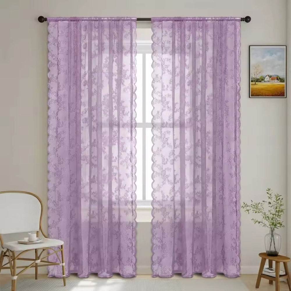 Pair of lilac floral lace curtain panels with scalloped edges hung on a dark rod at a window. 10
