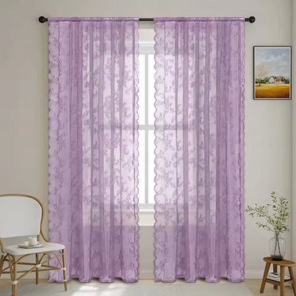 Pair of lilac floral lace curtain panels with scalloped edges hung on a dark rod at a window. 10