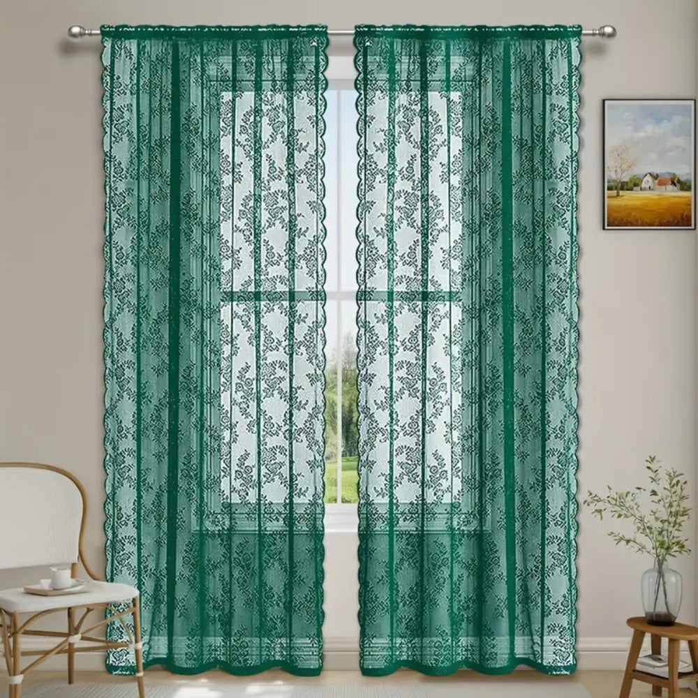 Pair of dark green floral lace curtain panels on a rod at a window, with scalloped edges, beside a chair. 5
