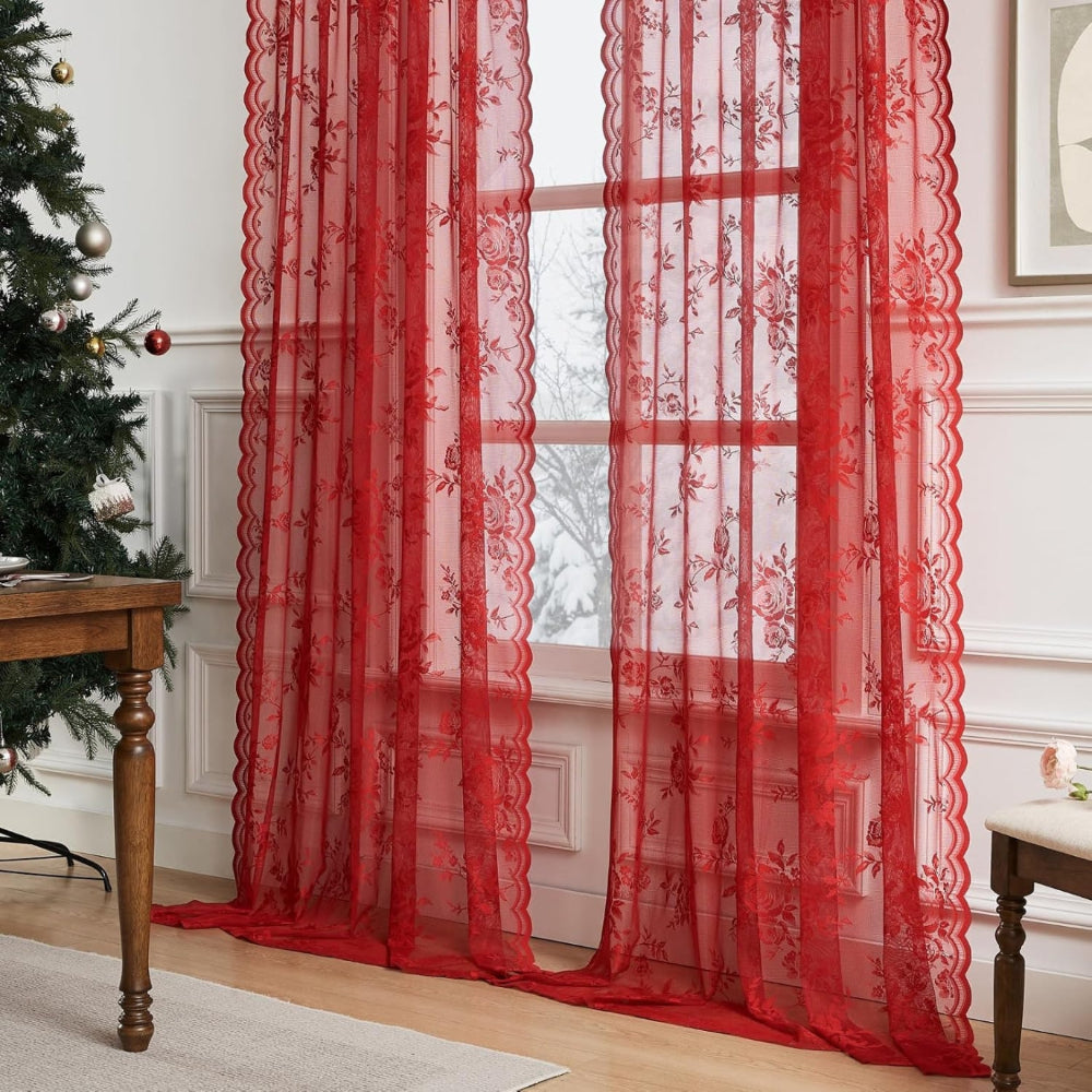 Bright red rose lace curtain panels with scalloped edges at a window beside a Christmas tree and wooden table. 7