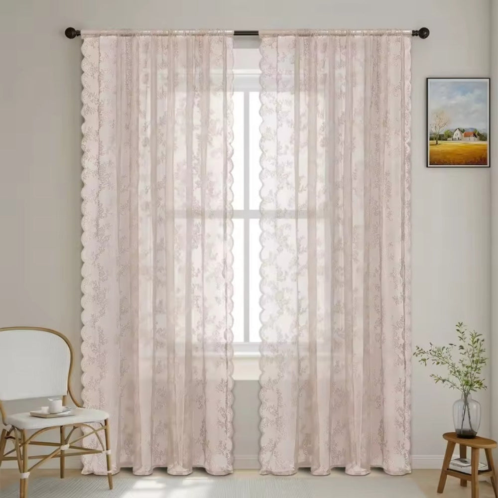 Pair of soft blush pink lace curtain panels with scalloped edges on a dark rod at a window. 9