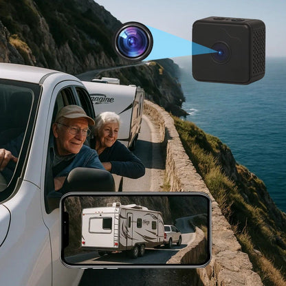 Older couple in a white pickup towing a caravan along a coastal road, with the small black camera and a phone showing the view behind. 1