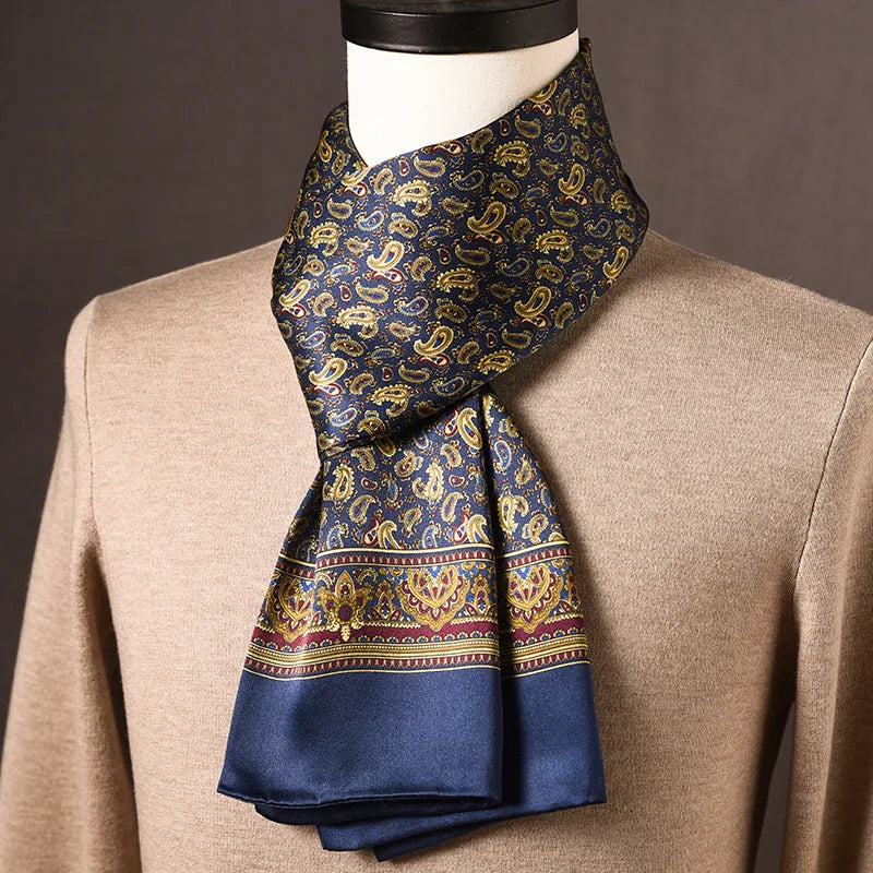 Navy silk scarf with golden paisley motifs and a burgundy and gold border, styled on a mannequin wearing a beige jumper. 12