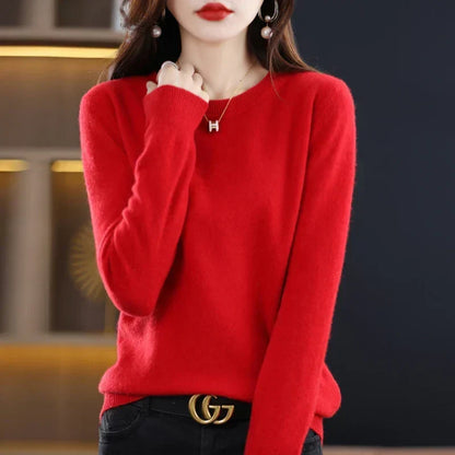 Bright red round-neck jumper worn with black jeans and a belt, hand raised towards the neckline 9