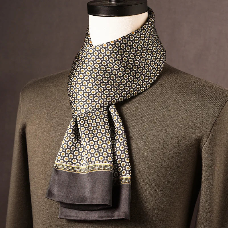 Dark grey silk scarf with small cream and gold floral medallions and a patterned border, on a mannequin in an olive jumper. 7