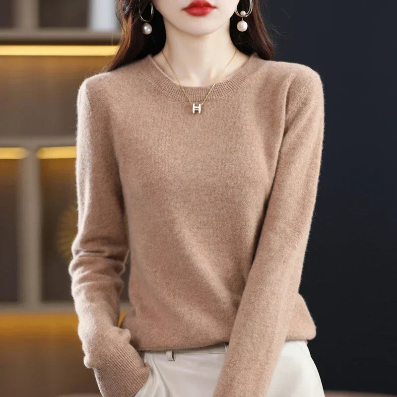 Model in a camel-coloured crew-neck jumper with ribbed cuffs, hand tucked into cream trouser pocket 3