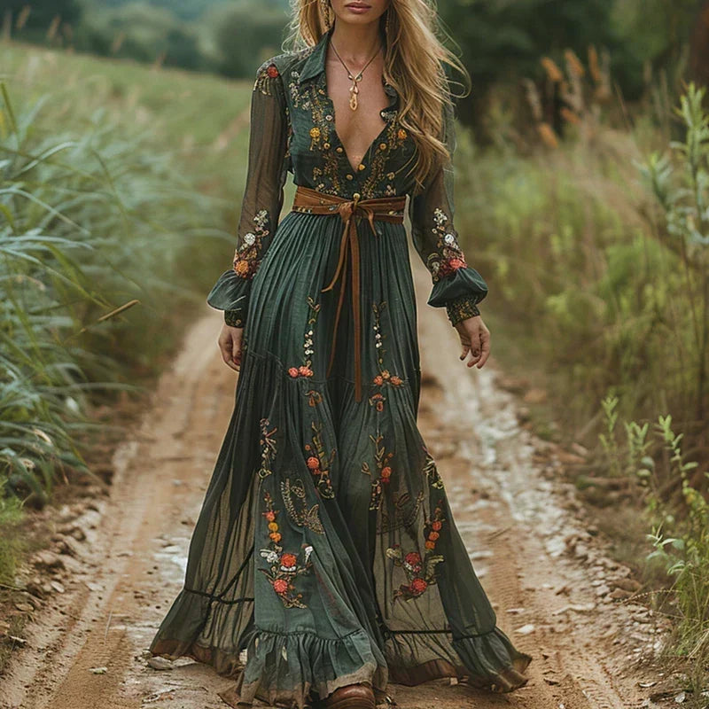 Model on a country track wearing the green maxi dress with floral embroidery and a tan tie belt 1