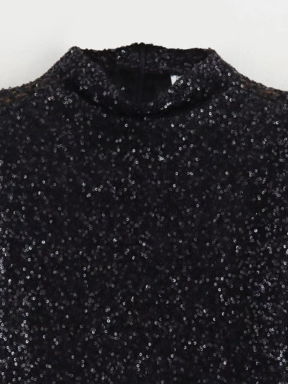 Close-up of the black sequin fabric at the high neckline, with a back zip visible 4