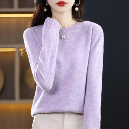 Pale lilac round-neck jumper with a soft texture, worn with cream trousers and hand raised to the shoulder 17